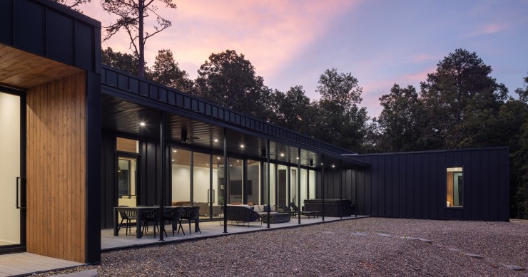 Los espacios comunes en concepto abierto están conectados con una terraza cubierta mediante grandes puertas correderas de cristal.