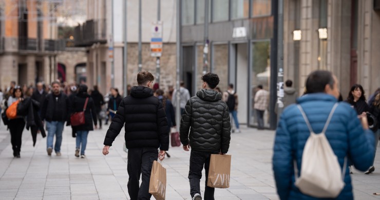 Archivo - Jóvenes sujetan bolsas con compras durante la campaña de Navidad de 2023.