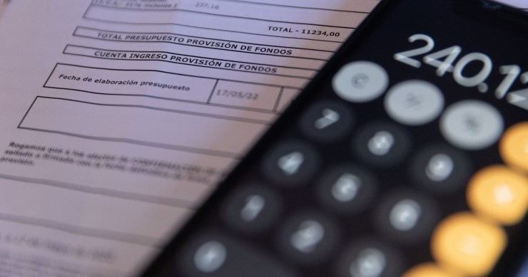 Archivo - Una calculadora y una escritura de compraventa de una vivienda, a 2 de junio de 2022, en Madrid (España).