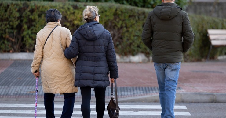 Archivo - Varias personas mayores de 55 años caminando por una calle de Madrid