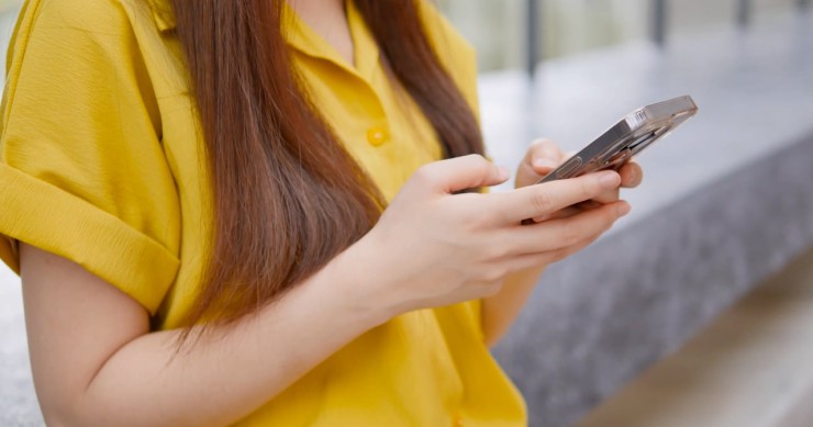 Usuaria de un móvil preocupada por un posible fraude Una mujer consulta su smartphone preocupada por un posible fraude online