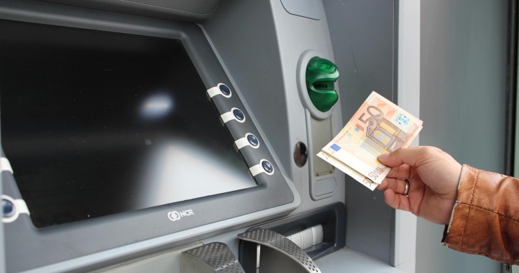Familiar sacando dinero de un cajero automático tras el fallecimiento de un familiar, posible aceptación tácita de herencia