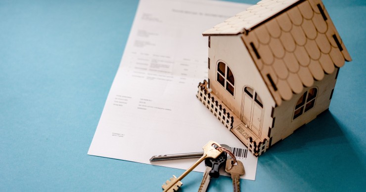 Miniatura de una casa sobre una escritura pública notarial