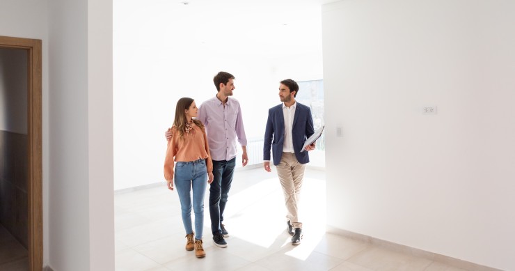 Un agente inmobiliario enseñando una casa a unos posibles compradores