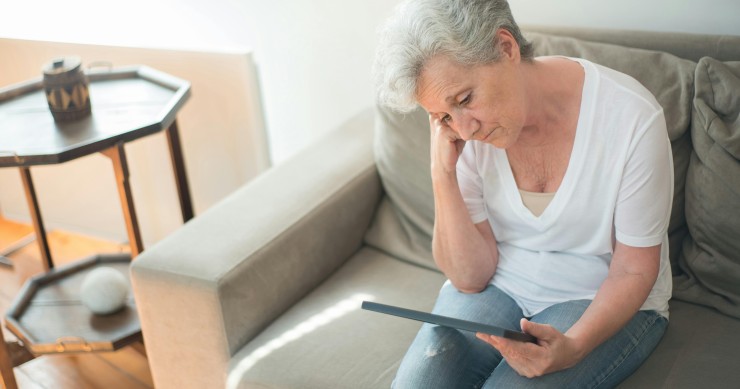 Anciana triste mirando una fotografía