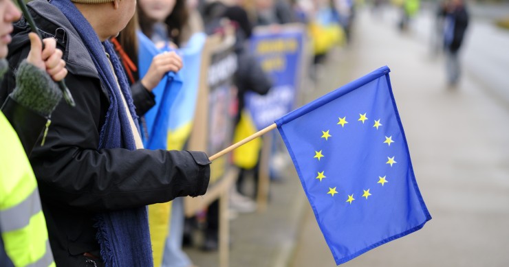 Un hombre sujetando una bandera de la Unión Europea