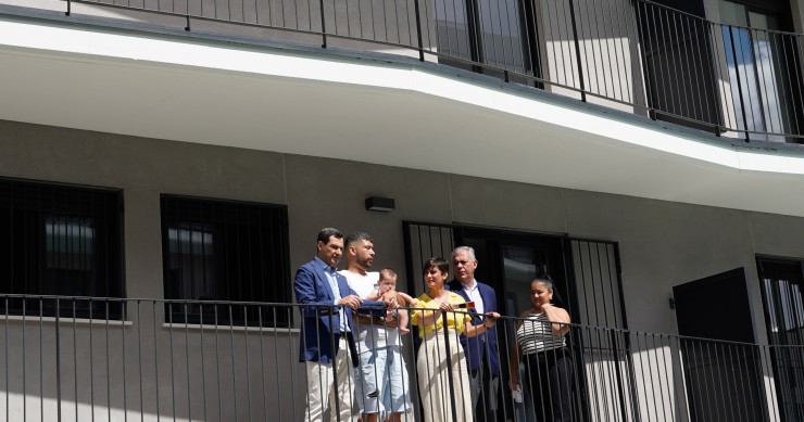 El presidente en funciones de la Junta de Andalucía, Juanma Moreno (1i), la ministra de Vivienda y Agenda Urbana, Isabel Rodríguez (3d), y el alcalde de Sevilla, José Luis Sanz (2d), visitan, junto a sus nuevos inquilinos, una de las viviendas de la promo