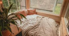 Una gran cama rodeada de ventanas