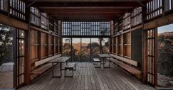 Interior de una de las cabañas con mesas y asientos