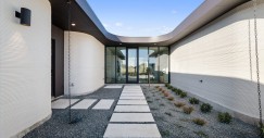 La vivienda se organiza con dos alas que se ramifican desde un gran salón central, albergando dormitorios y espacios comunes respectivamente.