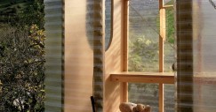Las planchas de policarbonato se curvan suavemente alrededor de la estructura de madera.