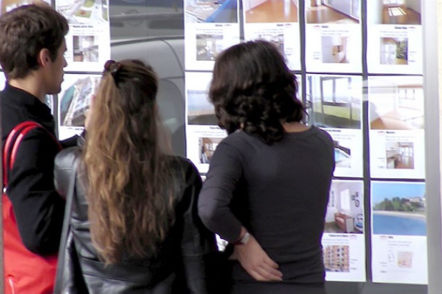 jóvenes mirando una inmobiliaria