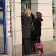 Dos mujeres autónomas suben la persiana metálica de su negocios en una imagen de archivo.