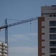 Archivo - Una grúa en una zona de construcción de edificios